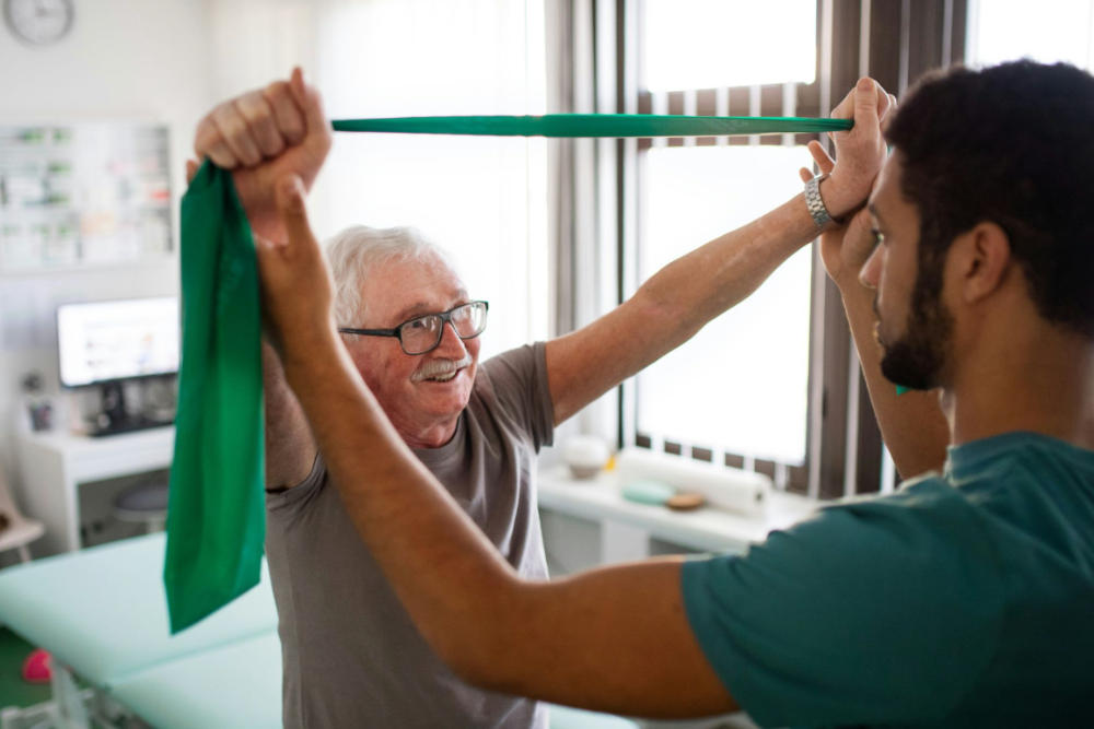 Physiothérapeute accompagnant une personne âgée dans des exercices d'équilibre à domicile